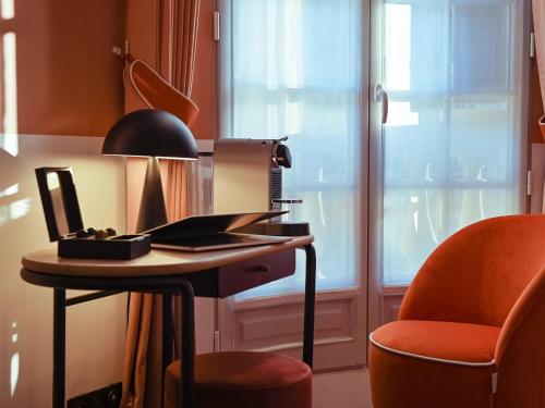 a desk with a chair next to a window at Mercure Paris Gare De Lyon Opera Bastille in Paris