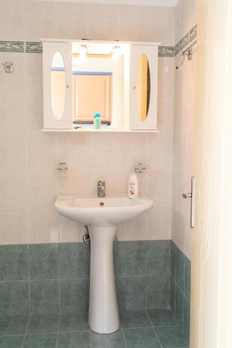 a bathroom with a sink and a mirror at Milos Studios in Lourdata