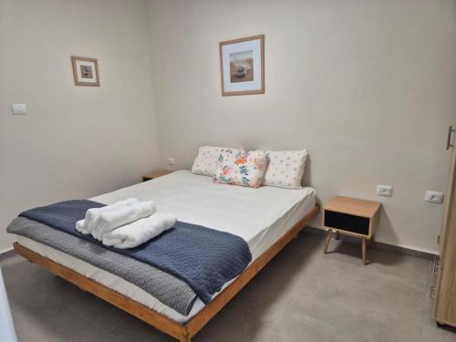 une chambre avec un lit avec des serviettes dessus dans l'établissement סוויטת ארגמן, à Beʼer Ora