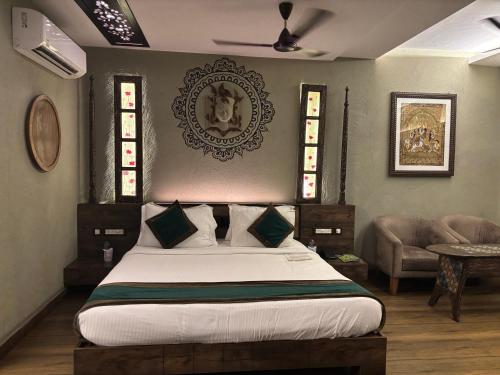 a bedroom with a large bed and a chair at Breathing Earth - Rooms and Pool in Kolkata