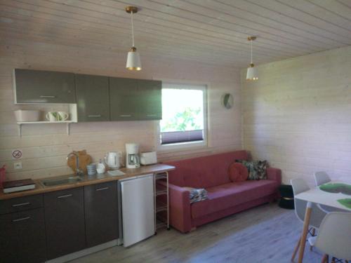 a kitchen and a living room with a red couch at Las Palmas in Kołczewo