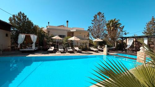 a large blue swimming pool with chairs and umbrellas at Theonia Villas in Pefki Rhodes