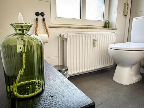 Un jarrón sobre una mesa en un baño con inodoro. en Große Wohnung in der KTV, en Rostock