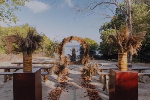 a group of tables with palm trees and an arch at Plataran Menjangan Resort and Spa - CHSE Certified in Banyuwedang