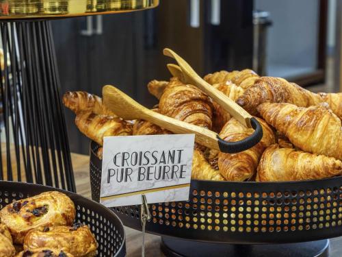 a basket of croissants and pastries on a table at Mercure Chur City West in Chur