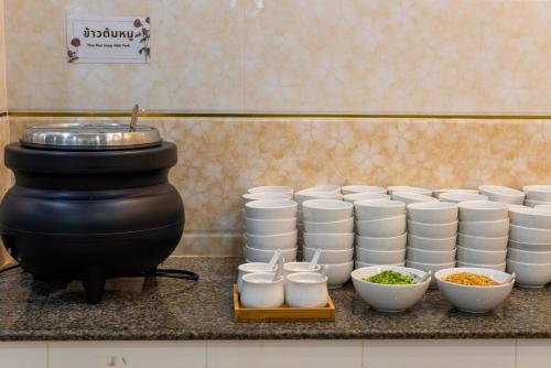 a counter with a bunch of cups and bowls on it at Chokdee Place in Sakon Nakhon