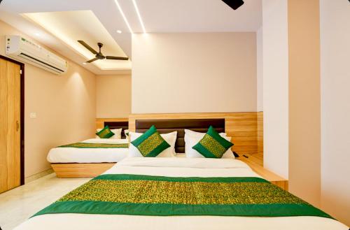 a bedroom with two beds with green pillows at Hotel Express 66 Just a Minute Away From New Delhi Railway Station Main Road in New Delhi