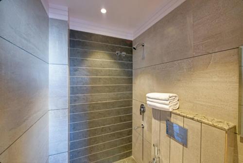 a bathroom with a shower with towels on a counter at Hotel Express 66 Just a Minute Away From New Delhi Railway Station Main Road in New Delhi