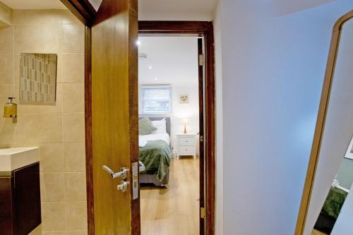a door leading to a bedroom with a bed at Imperial Argyle Square Apartment in London