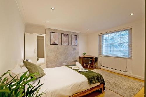 a bedroom with a large bed and a window at Imperial Argyle Square Apartment in London