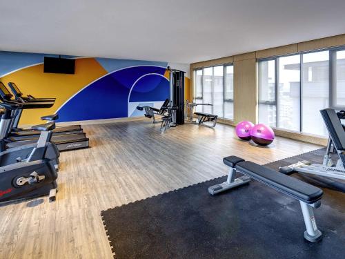 a gym with treadmills and exercise equipment in a room at Mercure Kuala Lumpur Glenmarie in Shah Alam
