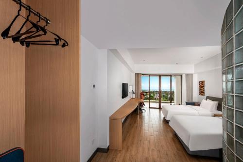 a hotel room with a bed and a living room at Holiday Inn Express Haikou West Coast by IHG in Haikou