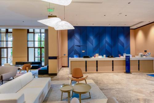 an office lobby with a blue wall at Holiday Inn Express Haikou West Coast by IHG in Haikou
