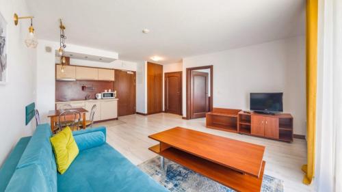 un soggiorno con un divano blu e un tavolo di Flatbook Apartamenty - Krynica Morska Margo a Krynica Morska