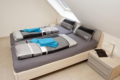 two beds in a bedroom with blue pillows at Perle von Borkum 2 in Borkum