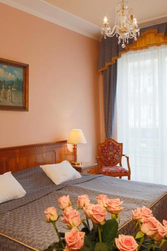 a bedroom with a bed with pink roses on it at Hotel Bristol in Karlovy Vary