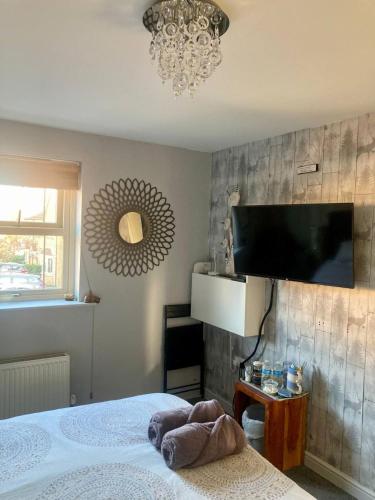 a bedroom with a bed and a flat screen tv at Sunset garden retreat in Morton