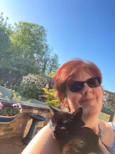 a woman in sunglasses holding a black cat at Sunset garden retreat in Morton