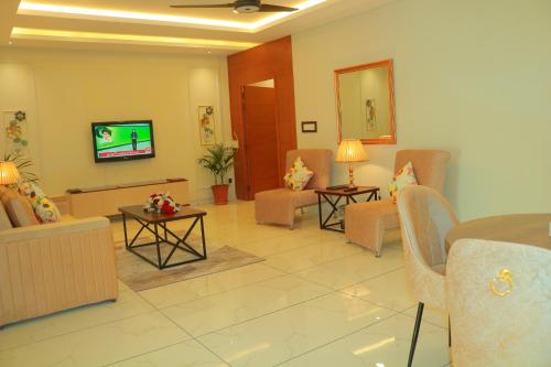 a waiting room with couches and a tv in it at Bahria Sunrise Apartments in Rawalpindi