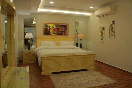 a bedroom with a large bed and a mirror at Bahria Sunrise Apartments in Rawalpindi