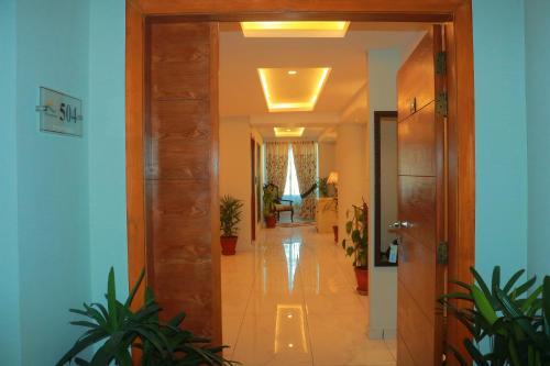 a hallway with a hallway leading into a room with plants at Bahria Sunrise Apartments in Rawalpindi