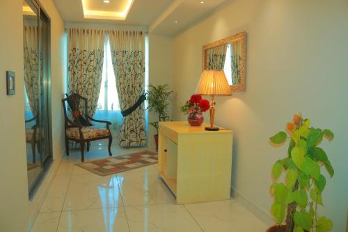 a living room with a table with a lamp and a chair at Bahria Sunrise Apartments in Rawalpindi