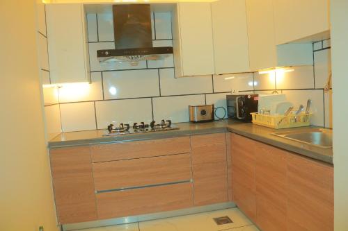 a kitchen with wooden cabinets and a sink at Bahria Sunrise Apartments in Rawalpindi