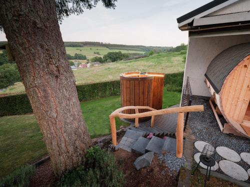 a wooden chair sitting next to a tree at Chalet Panor'Anna in Saint-Vith