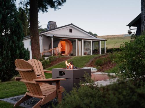 a fire pit and two chairs in a yard at Chalet Panor'Anna in Saint-Vith