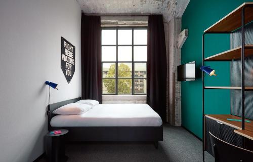 a small bedroom with a bed and a window at The Social Hub Maastricht Extended Stay in Maastricht