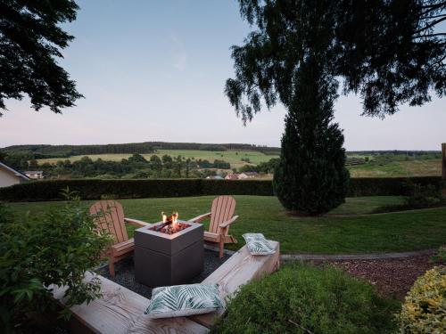 two chairs and a fire pit in a yard at Chalet Panor'Anna in Saint-Vith