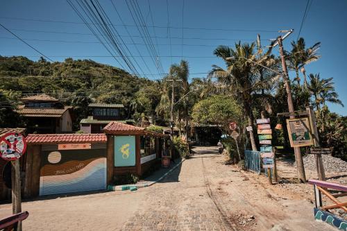a dirt road in a village with a mountain at Pousada Amô in Guarda do Embaú