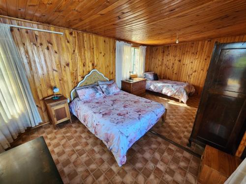 ein Schlafzimmer mit zwei Betten in einem Holzzimmer in der Unterkunft Paradys in Clanwilliam