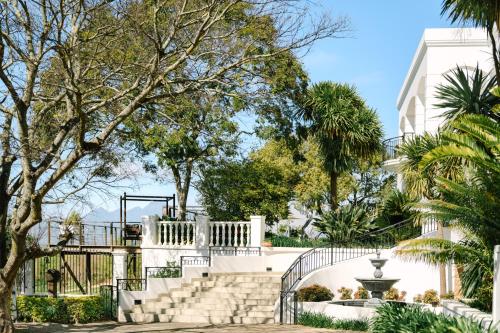 a staircase in a park with trees and a building at The Salene Hotel & Apartments in Stellenbosch