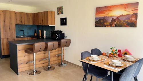 a kitchen with a table with chairs and a painting on the wall at Neue und sonnige Doppelhaushälfte in Dobl bei Graz Top 2 in Dobl