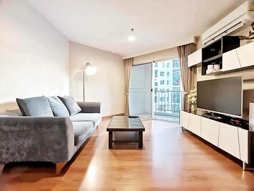 a living room with a couch and a tv at Belle Grand Rama 9 Bangkok in Bangkok