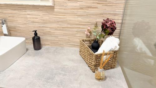 a bathroom with a sink and a basket with flowers at Short Stay Cosbuc in Baia Mare