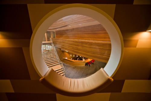 a spiral staircase in a building with a round window at Hotel Udens Duyn in Uden