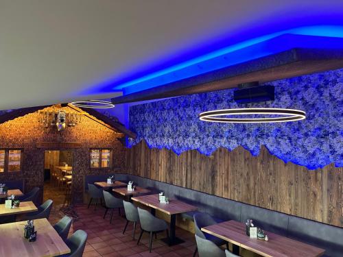 a restaurant with wooden tables and blue lighting at Hotel Am Kamin in Kaufbeuren