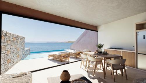 a kitchen and dining room with a view of the ocean at Volta Seaside Boutique Hotel in Kokkíni Khánion