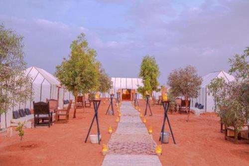 une rangée de tentes dans un champ arboré dans l'établissement Merzouga conventional camp, à Merzouga