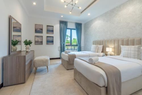 a bedroom with two beds and a desk and a mirror at Luxury Beachfront Villa with Direct Beach Access, Next to Community Pool, Close to the Thrills of Aquaventure Waterpark, Canal Cove, Palm Jumeirah by Deluxe Holiday Homes in Dubai
