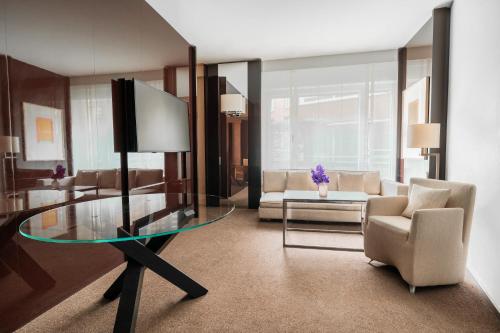 a living room with a glass table and a couch at Grand Hyatt Berlin in Berlin