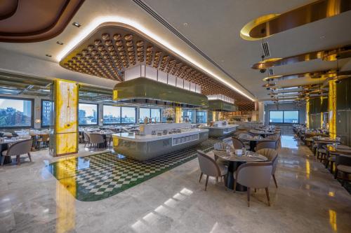 a restaurant with tables and chairs in a building at Chamada Girne Hotel Spa and Casino in Kérynia