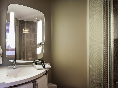 a bathroom with a sink and a mirror at ibis Sens in Sens