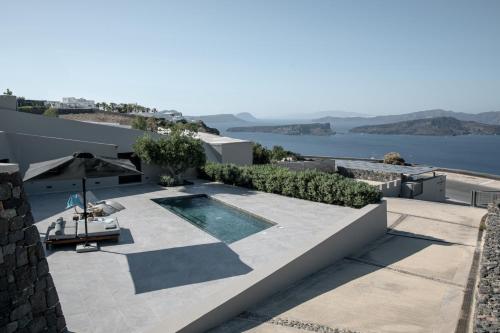 a villa with a swimming pool on top of a house at Melidonia Suites in Akrotiri