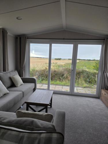 ウィットリー・ベイにあるLighthouse and sea viewsのソファとテーブルのあるリビングルーム