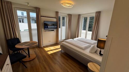 a bedroom with a bed and a table and a television at Hotel Asgards Midgard in Zinnowitz