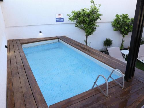 une grande piscine avec une terrasse en bois et une piscine dans l'établissement וילה Mandala אירוח&אירועים, 