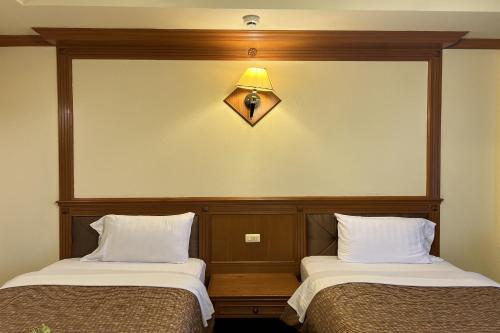 Postel nebo postele na pokoji v ubytování Taksila Hotel